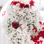 addobbo centrotavola con rose rosse e orchidee su base di velo da sposa